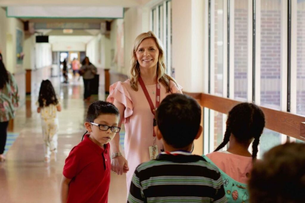 Picture of a calm hallway scene with students walking safely and adult support