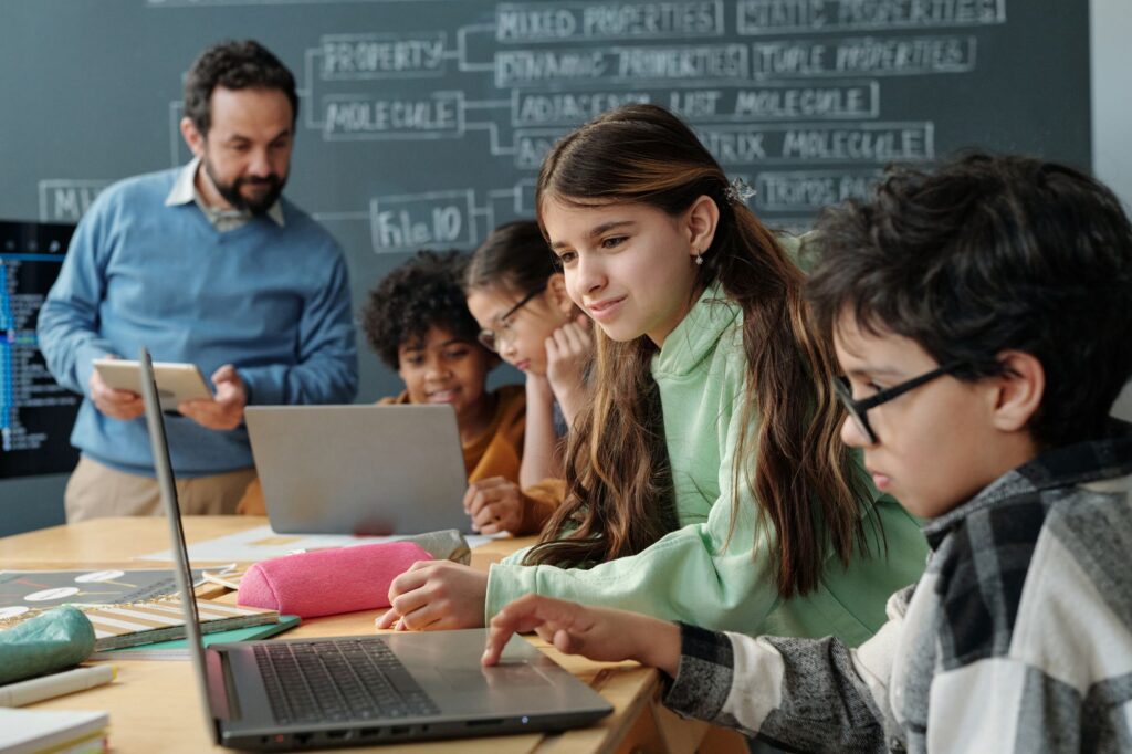 Picture of a teacher confidently interacting with students who are smiling, attentive and relaxed